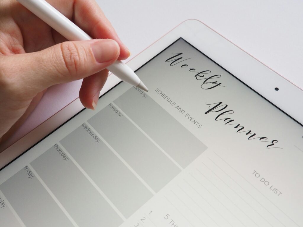 pexels-photo-768472-768472-1 A stylus writing in a digital weekly planner on a tablet screen, ideal for organization.